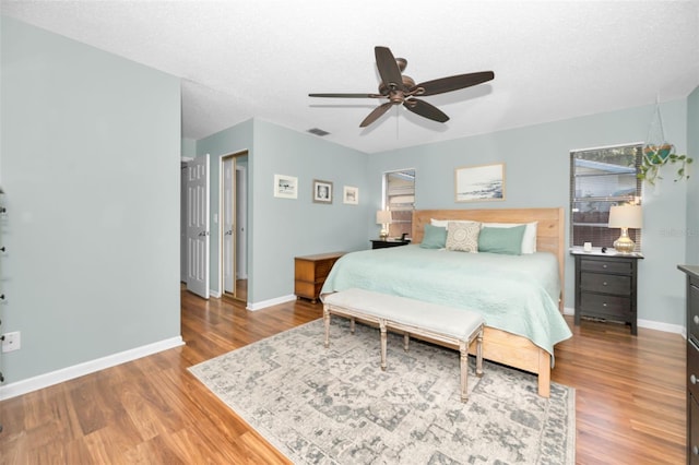 bedroom featuring ceiling fan, a textured ceiling, and hardwood / wood-style flooring