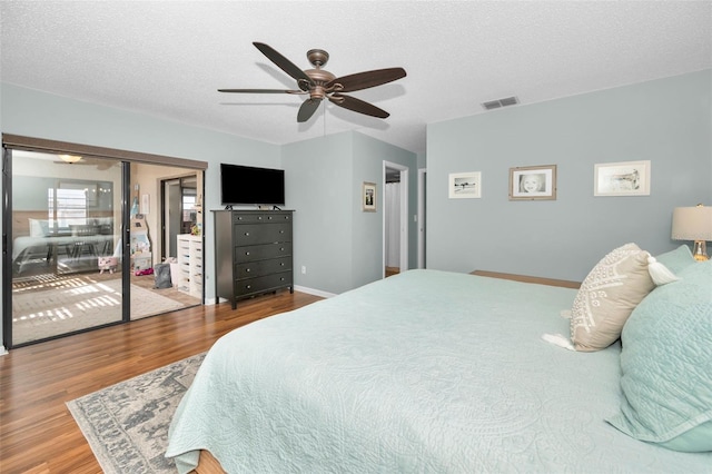 bedroom with ceiling fan, a closet, wood-type flooring, and a textured ceiling