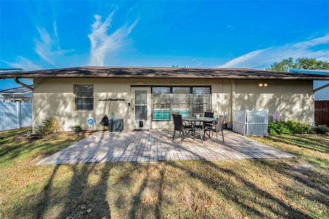 rear view of property featuring a lawn, cooling unit, and a patio