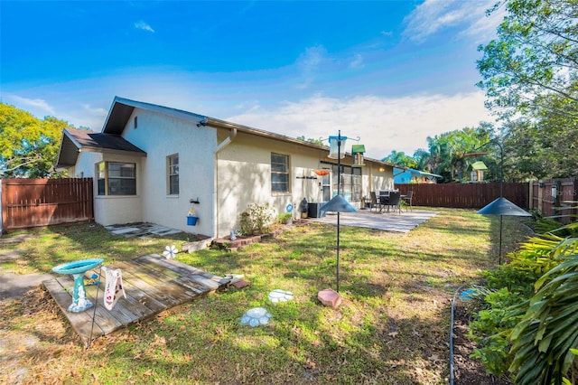 rear view of house featuring cooling unit, a yard, and a patio