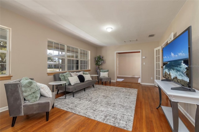 interior space featuring baseboards, visible vents, and wood finished floors