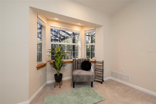 living area featuring carpet floors, visible vents, and baseboards