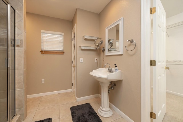 full bathroom featuring a stall shower, baseboards, and tile patterned floors