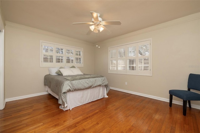 bedroom featuring ornamental molding, wood finished floors, a ceiling fan, and baseboards