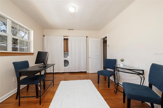 office with washer / dryer, baseboards, visible vents, and wood finished floors