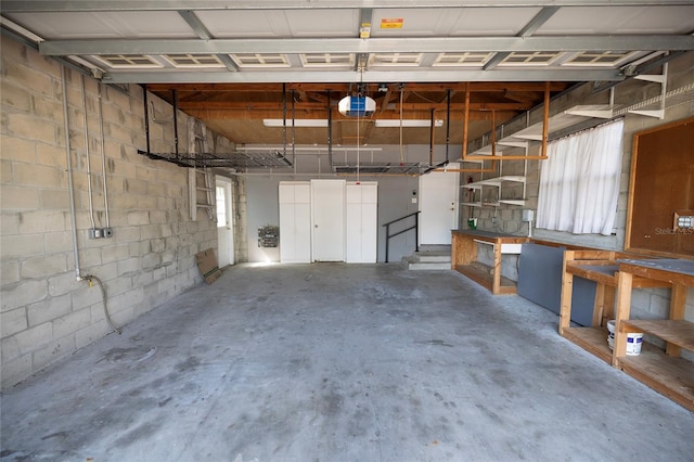 garage featuring a garage door opener and concrete block wall