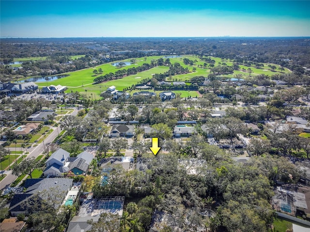 drone / aerial view featuring a residential view, view of golf course, and a water view