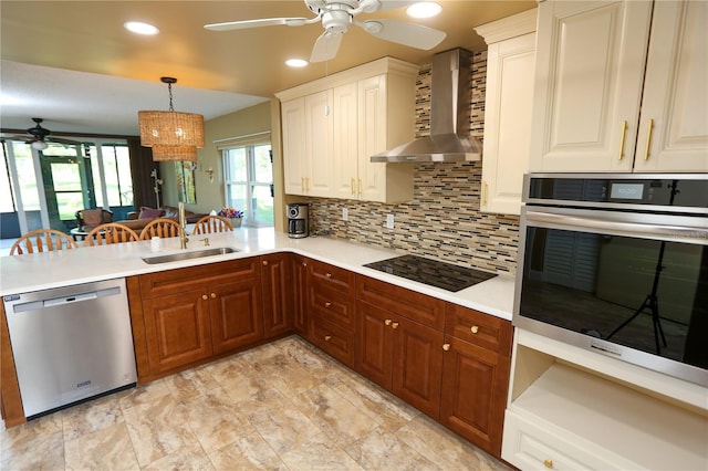 kitchen with sink, wall chimney exhaust hood, stainless steel appliances, decorative light fixtures, and decorative backsplash