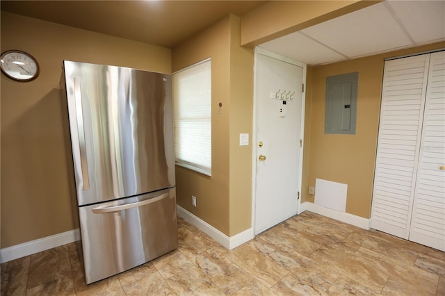 kitchen with stainless steel refrigerator, electric panel, and a paneled ceiling