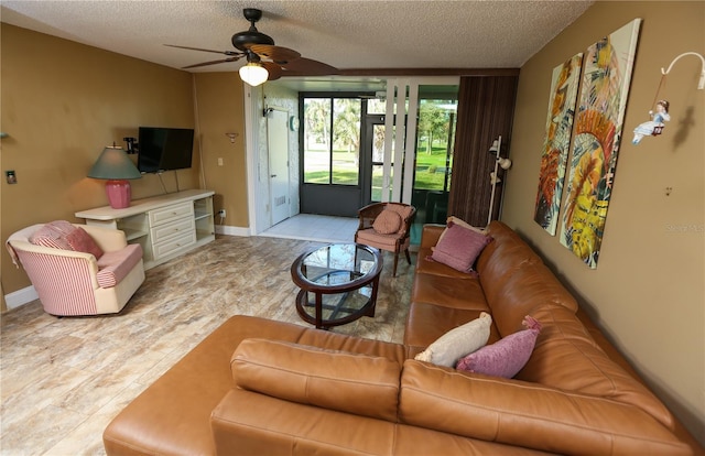 living room featuring ceiling fan and a textured ceiling