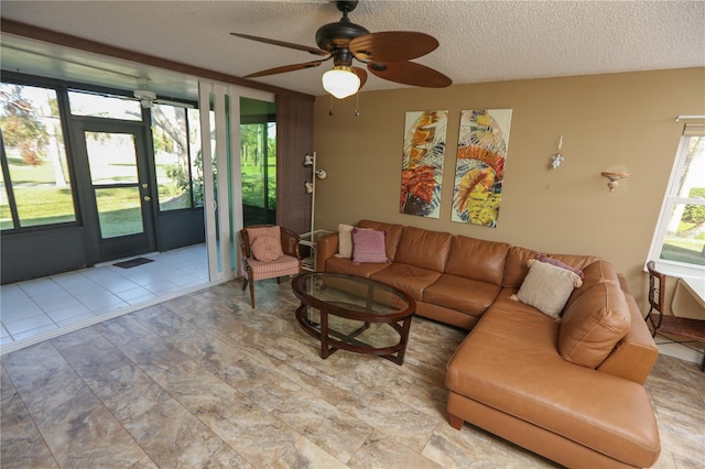 living room with a textured ceiling and ceiling fan