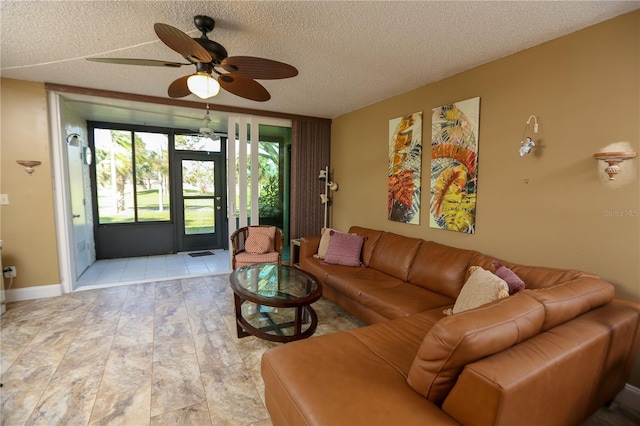 living room featuring ceiling fan, light hardwood / wood-style flooring, and a textured ceiling