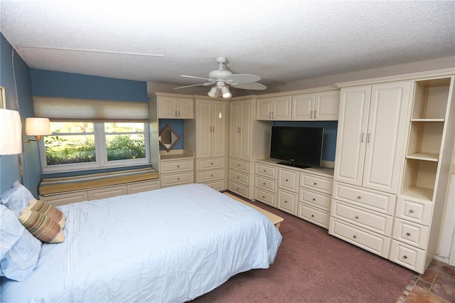 bedroom featuring a textured ceiling, dark carpet, and ceiling fan