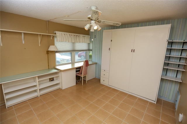 interior space with ceiling fan and a textured ceiling