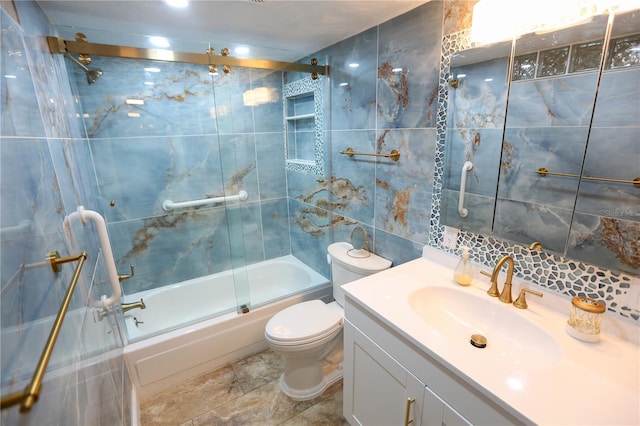 full bathroom featuring shower / bath combination with glass door, vanity, tile walls, and toilet