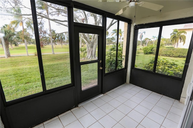 unfurnished sunroom featuring ceiling fan and a healthy amount of sunlight