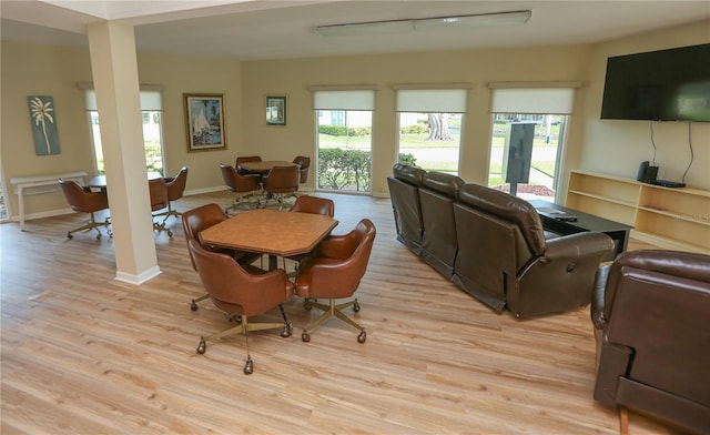 dining area featuring light wood-type flooring and a healthy amount of sunlight