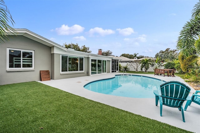 view of swimming pool with a patio area and a lawn