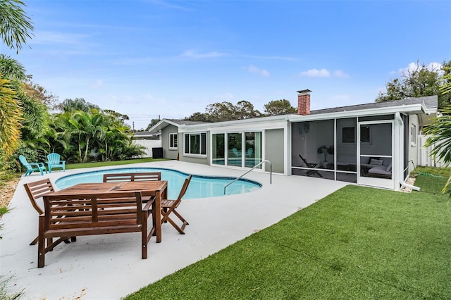 view of pool with a yard, a patio area, and a sunroom