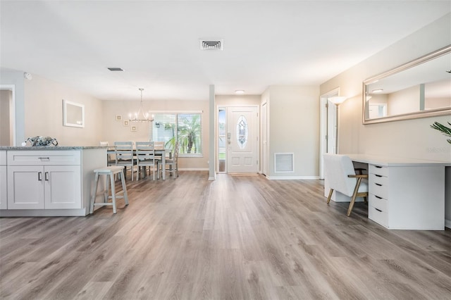 foyer entrance featuring a chandelier and light hardwood / wood-style floors