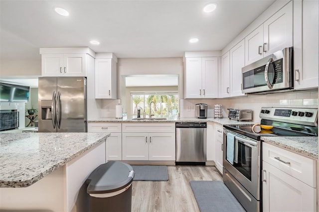 kitchen featuring white cabinetry, appliances with stainless steel finishes, and tasteful backsplash