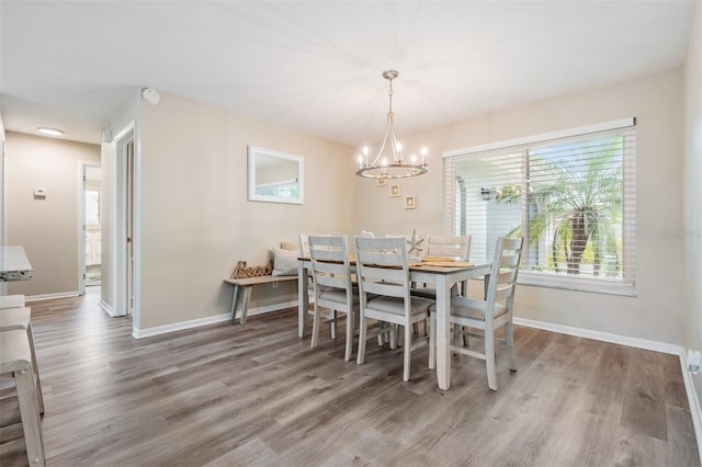 dining room with hardwood / wood-style flooring and a chandelier