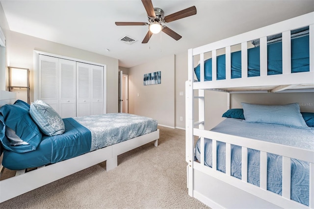 carpeted bedroom with ceiling fan and a closet