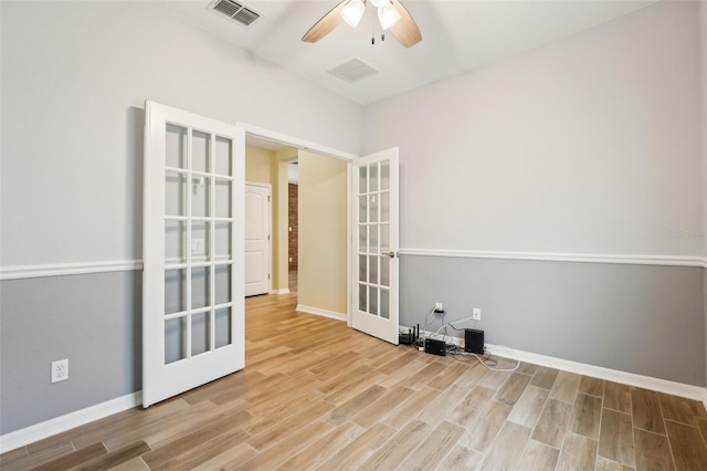 empty room featuring ceiling fan, french doors, and light wood-type flooring