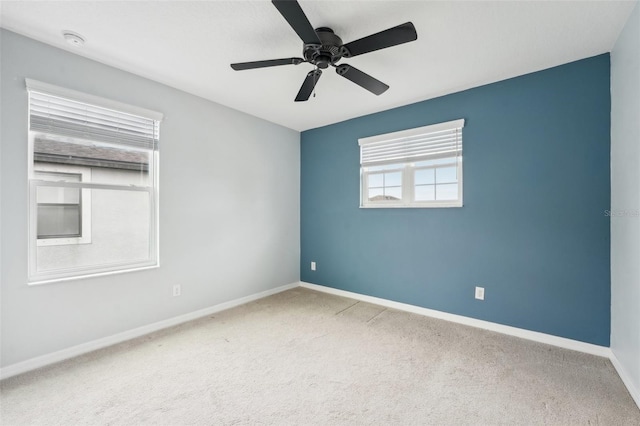 carpeted spare room with ceiling fan