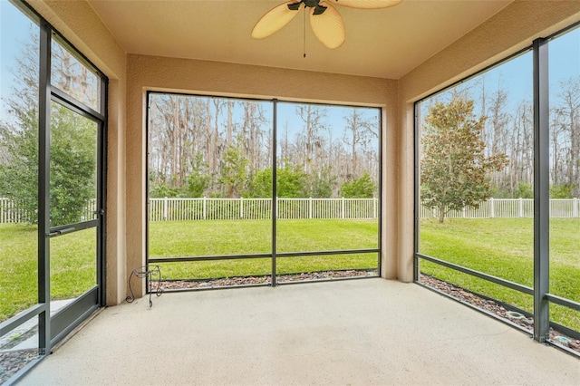 unfurnished sunroom featuring ceiling fan