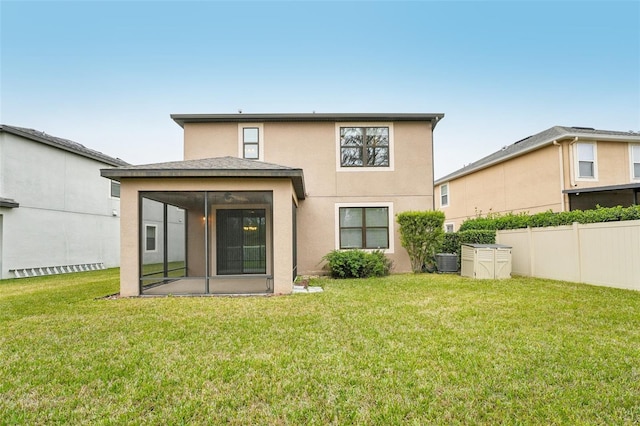 back of property with a sunroom, central air condition unit, and a lawn