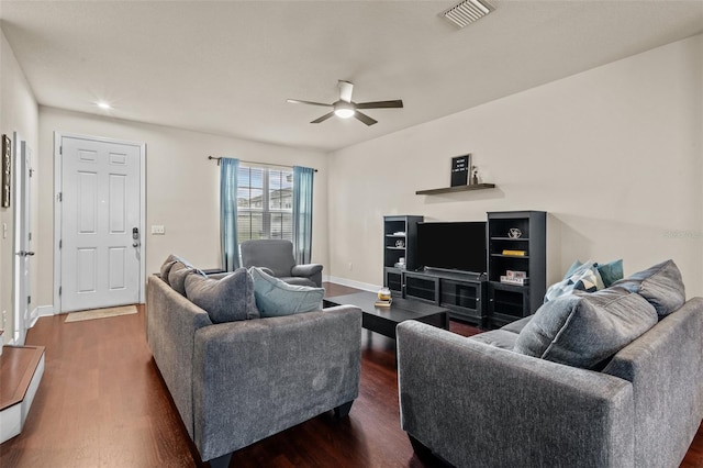 living room with ceiling fan and dark wood-type flooring