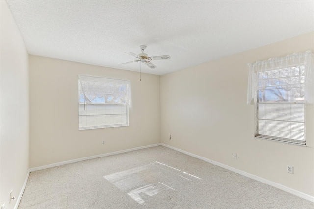 unfurnished room with ceiling fan, light colored carpet, and a textured ceiling