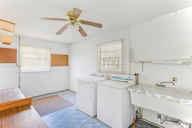 washroom featuring a textured ceiling, ceiling fan, washer and dryer, and sink