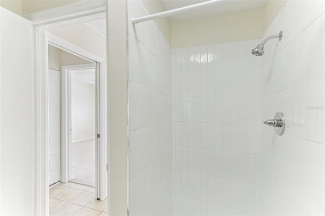 bathroom with tile patterned flooring and a tile shower