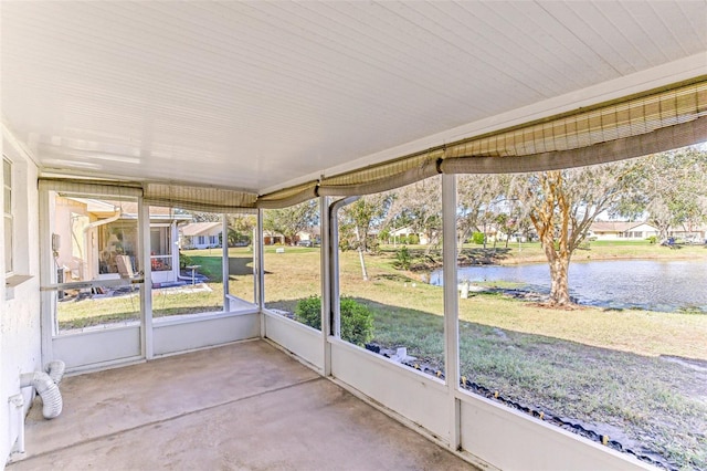 unfurnished sunroom featuring a water view