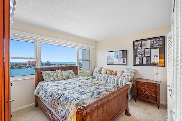 bedroom featuring a water view and light colored carpet