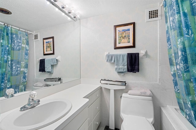 full bathroom with vanity, toilet, a textured ceiling, tile walls, and shower / tub combo with curtain