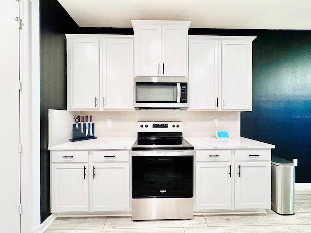 kitchen featuring stainless steel appliances and white cabinetry