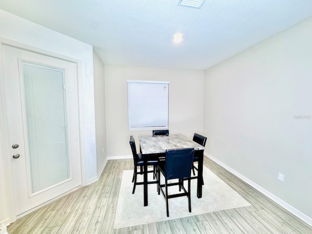 dining space with light hardwood / wood-style flooring