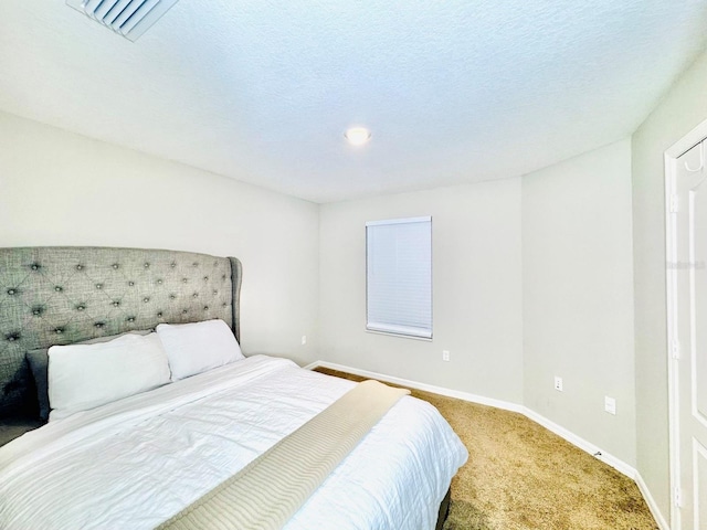 carpeted bedroom with a textured ceiling