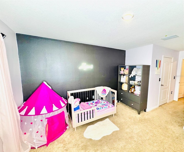 bedroom featuring light colored carpet and a textured ceiling