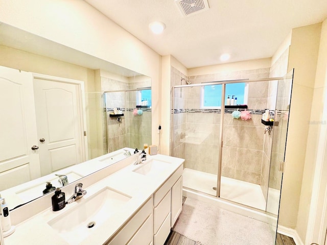 bathroom with vanity and a shower with shower door