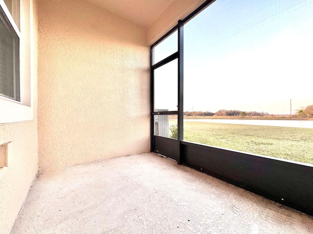 unfurnished sunroom with a water view