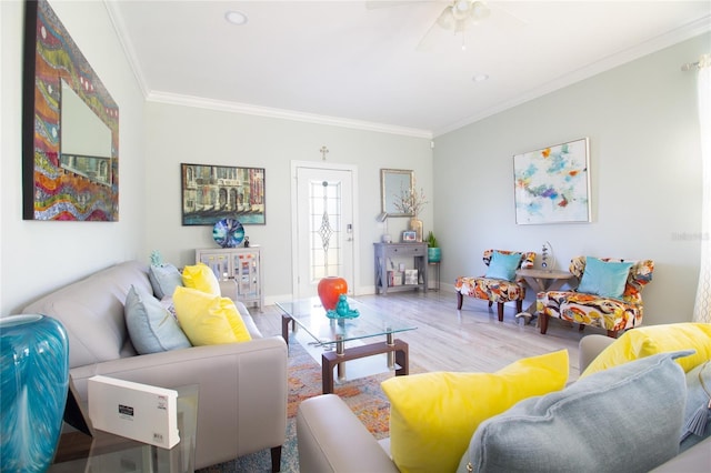 living room featuring hardwood / wood-style floors, ceiling fan, and crown molding