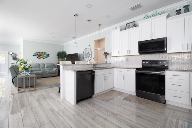 kitchen with black appliances, sink, white cabinets, and hanging light fixtures