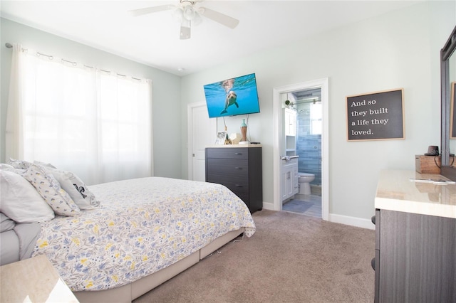 carpeted bedroom with ceiling fan and ensuite bath