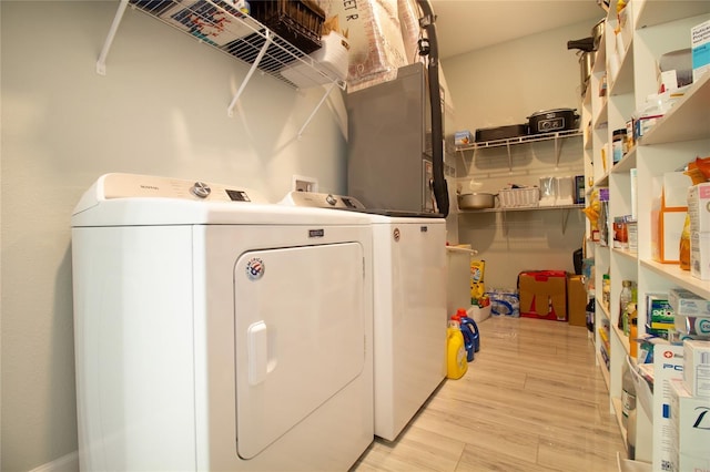 laundry area featuring washer and clothes dryer and light hardwood / wood-style floors