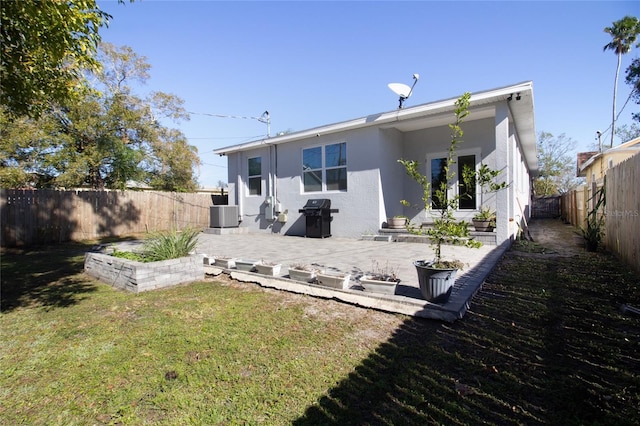 rear view of house with central AC unit, a patio area, and a yard