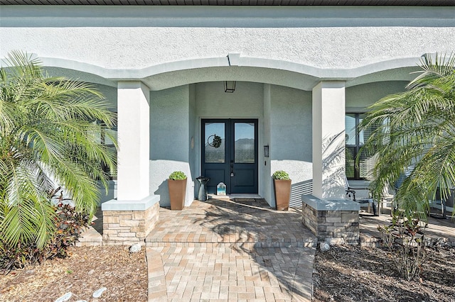 property entrance with covered porch and french doors